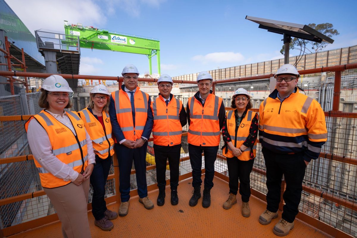 Group of people with hard hats and high-vis vests on at a construction site.