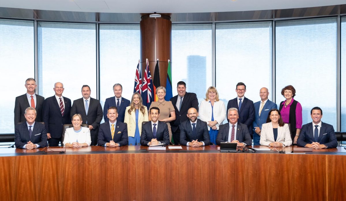 The full Queensland LNP ministry gathered behind a long wooden table.