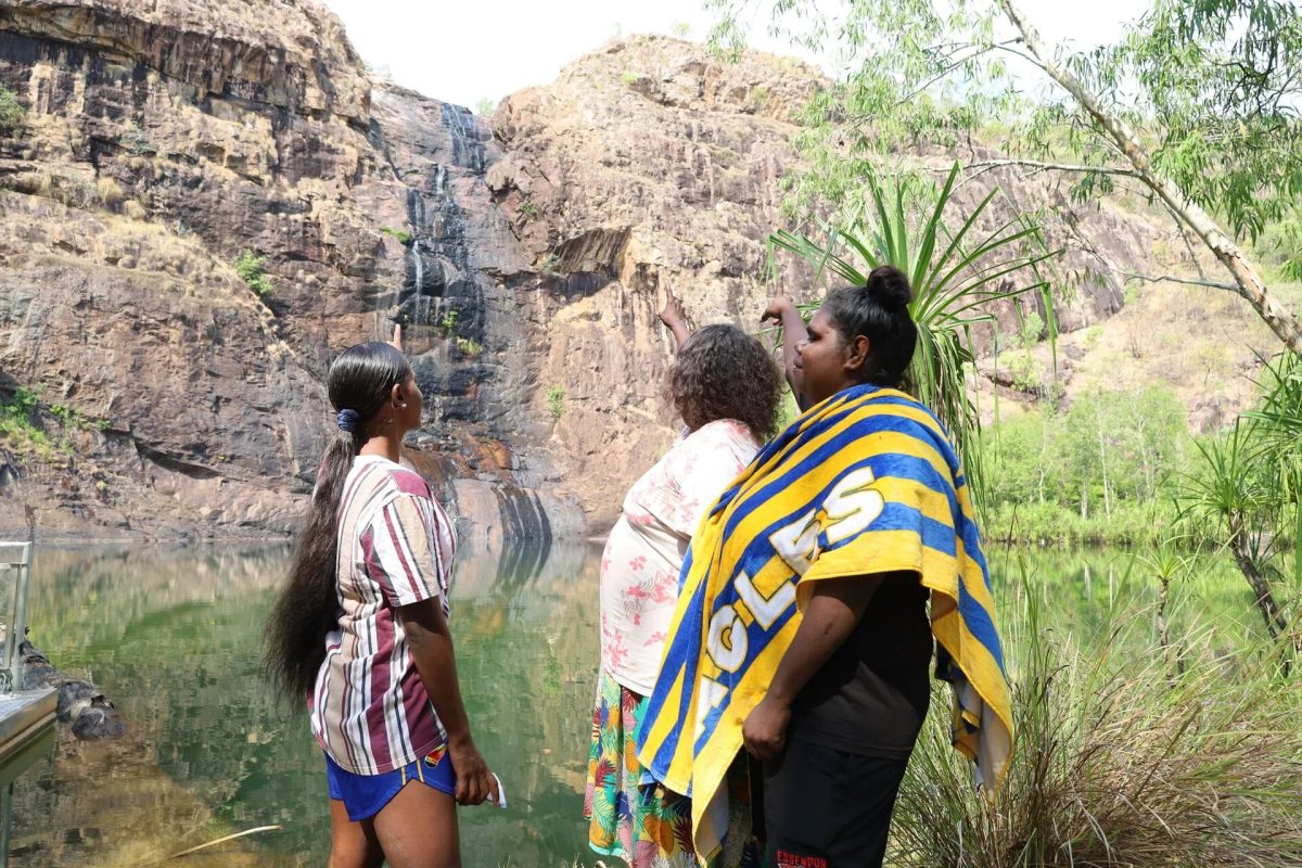 three Jawoyn women standing before Gunlom Falls