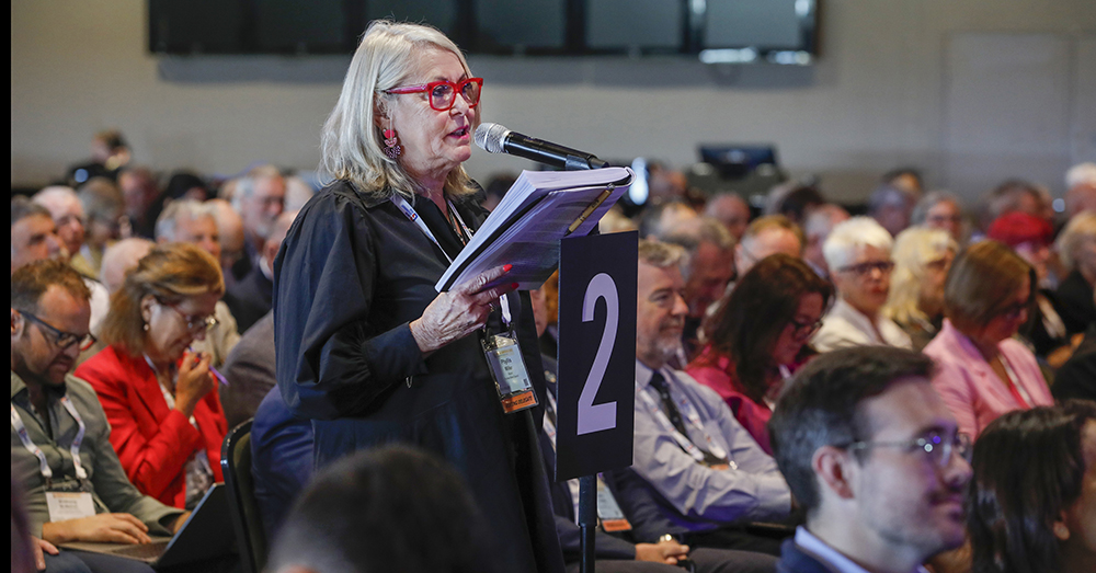 A woman in the audience speaking at a conference