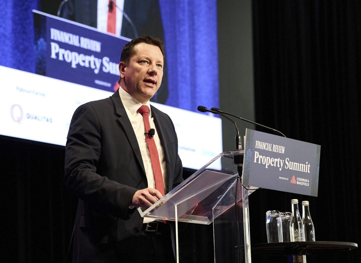 A man on stage speaking at a conference