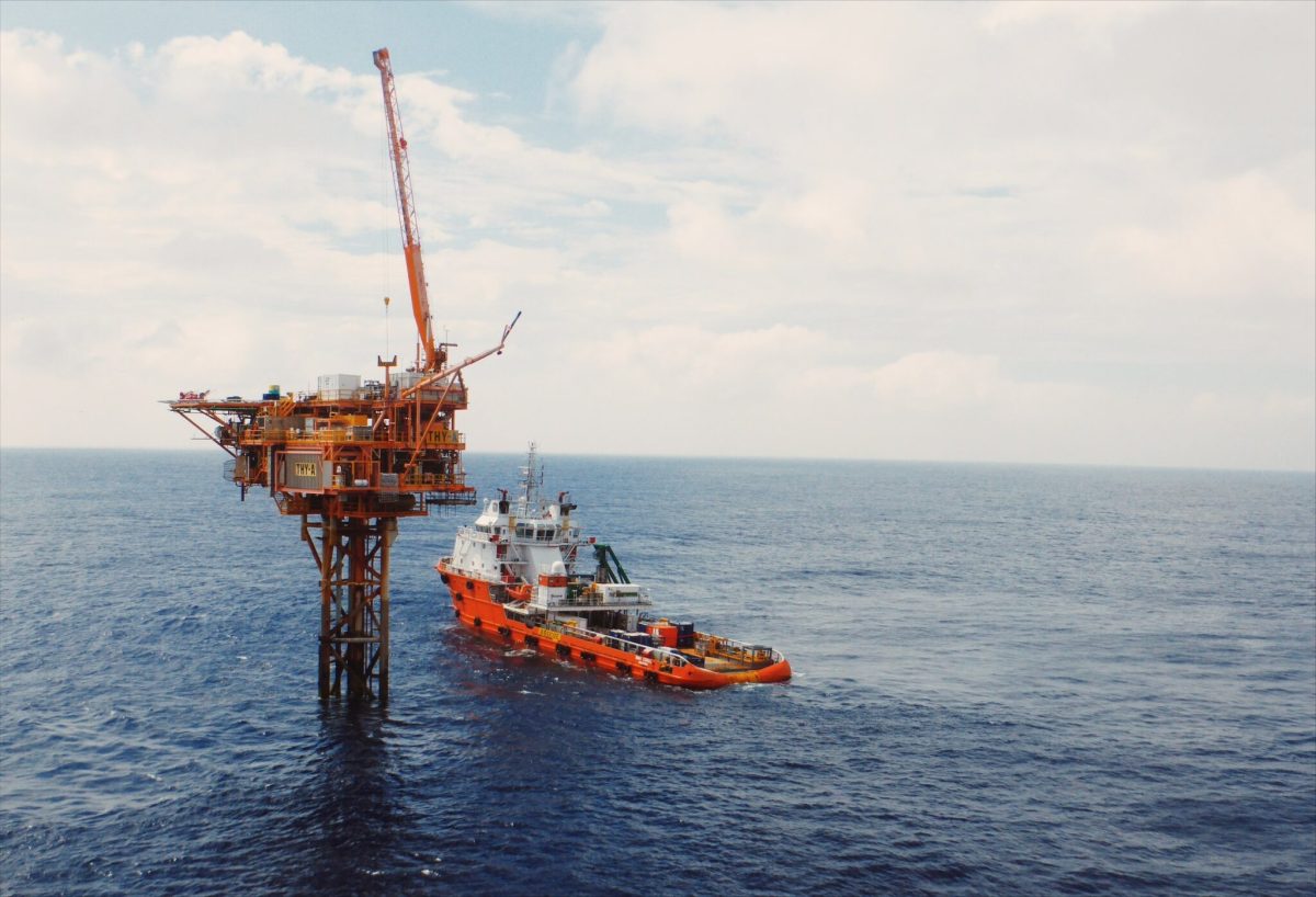 Gas extraction off-shore platform with a ship next to it.