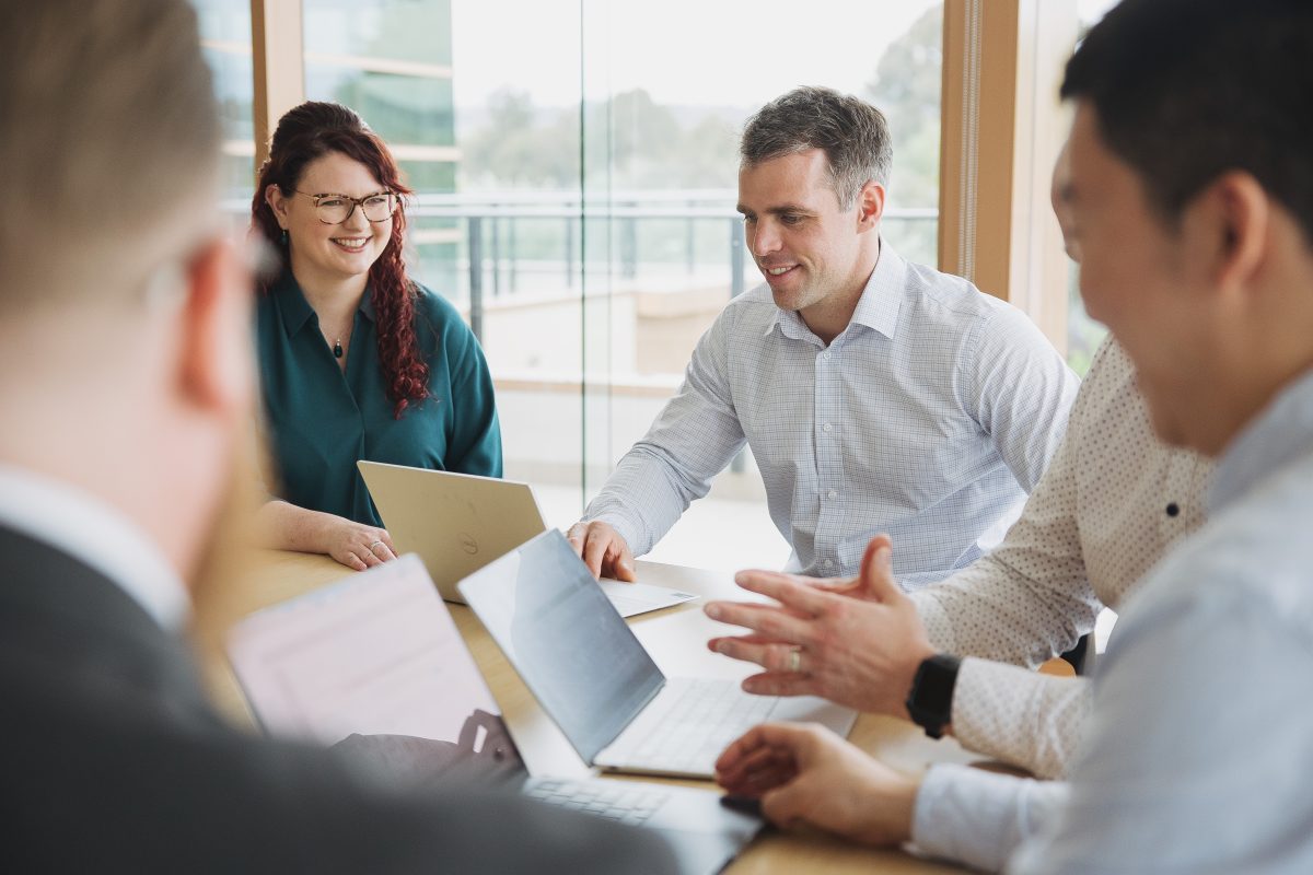 Group sitting in office looking at computers.