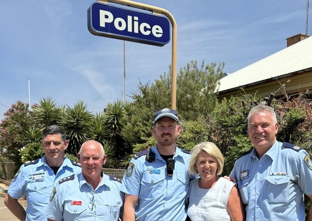 a woman with four federal police officers outside a police station