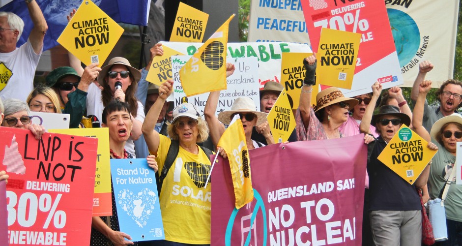 A group of environmental activists rallying with various signs and flags against nuclear.