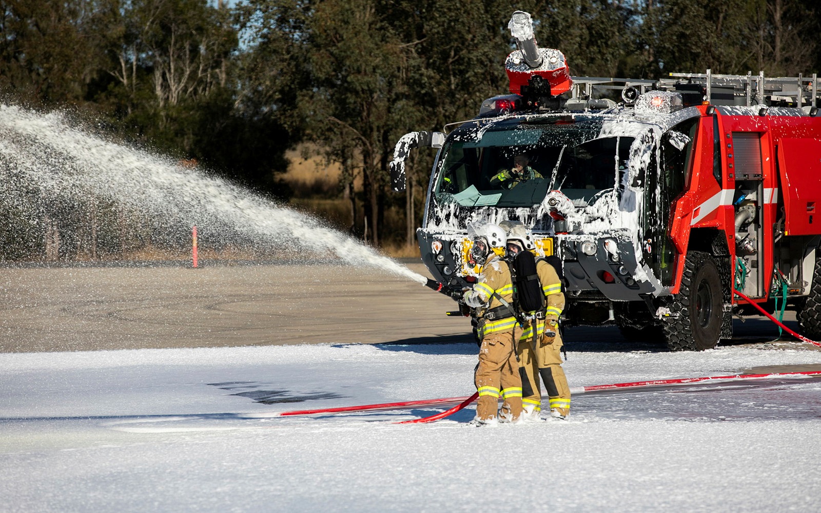 Airport firefighters spraying foam