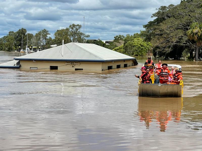 emergency workers on a boat in floodwaters