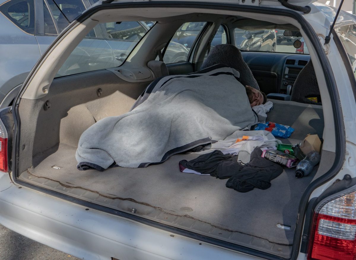 Homeless man sleeping in the back of a car