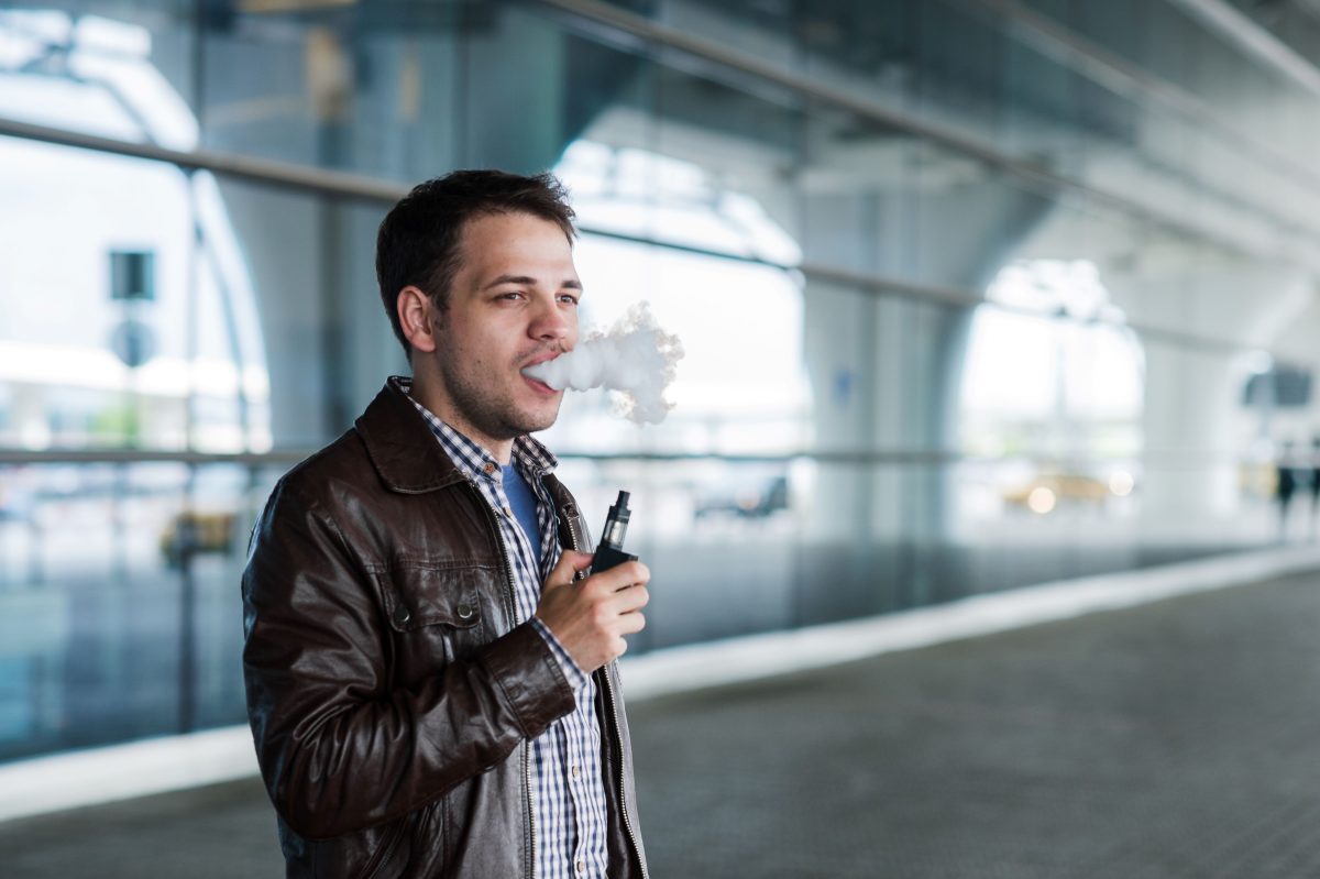 a man vaping at a train station