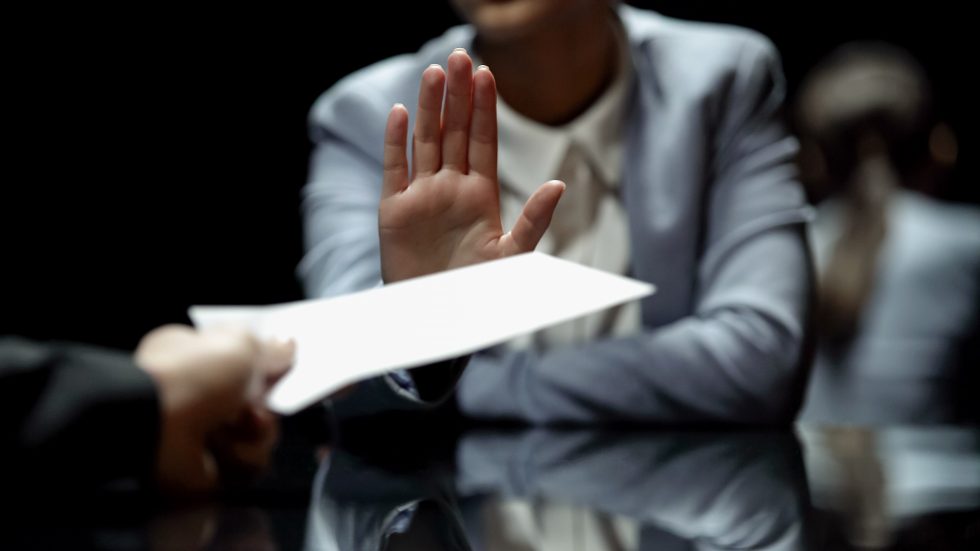 Man holding up hand to refuse an offer
