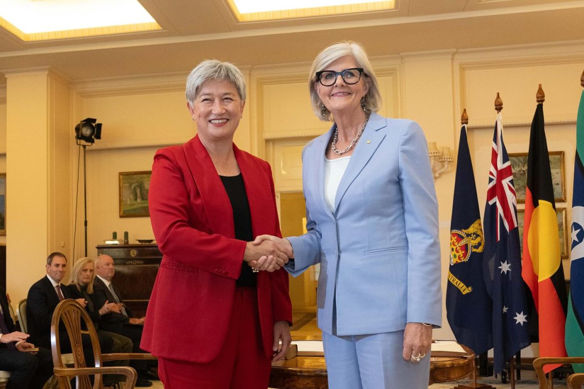 two women shaking hands during a governmental swearing-in ceremony