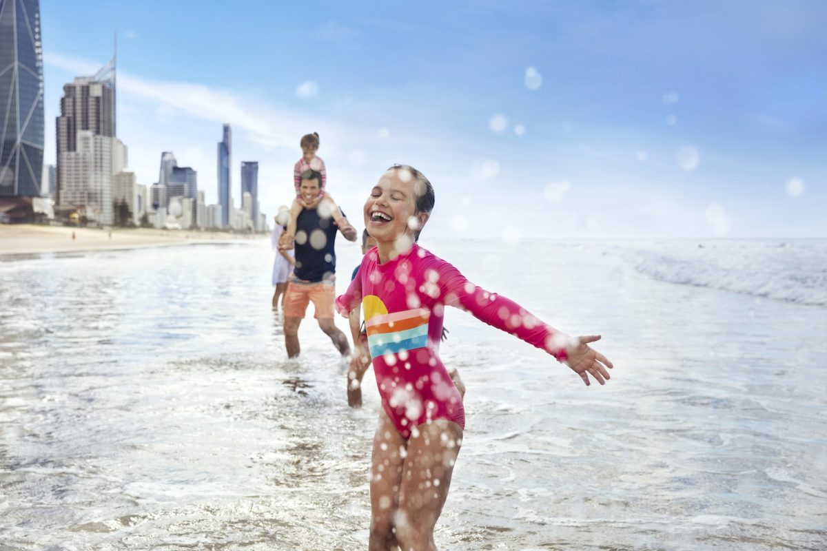 a dad and kids in the water at the beach