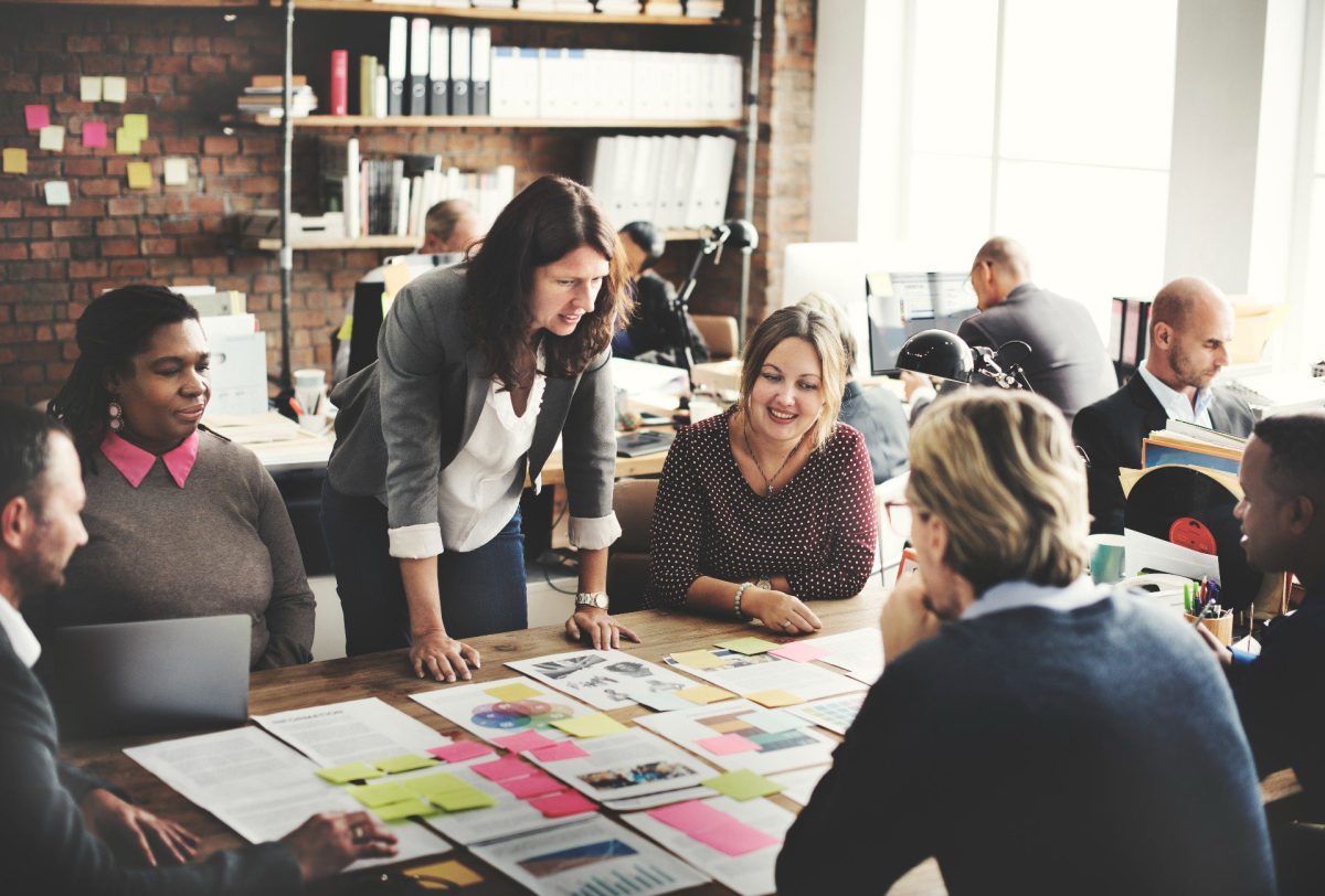 a group of people looking at papers on an office table