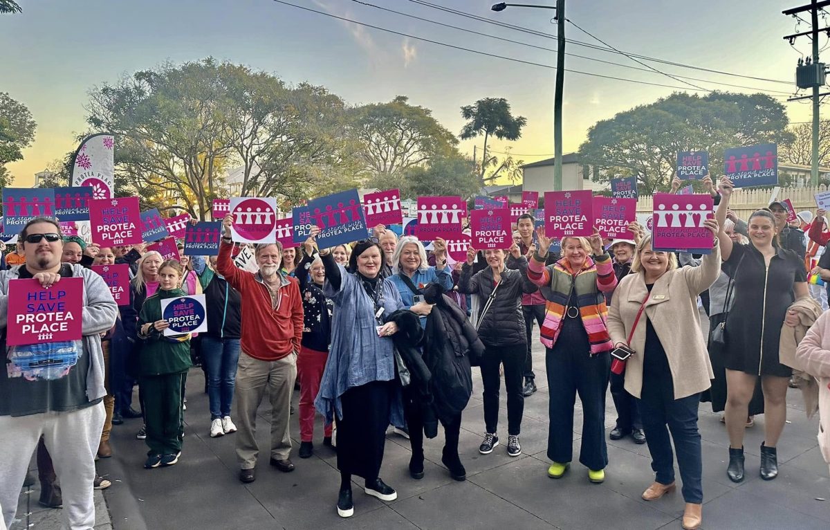 people holding signs at a rally