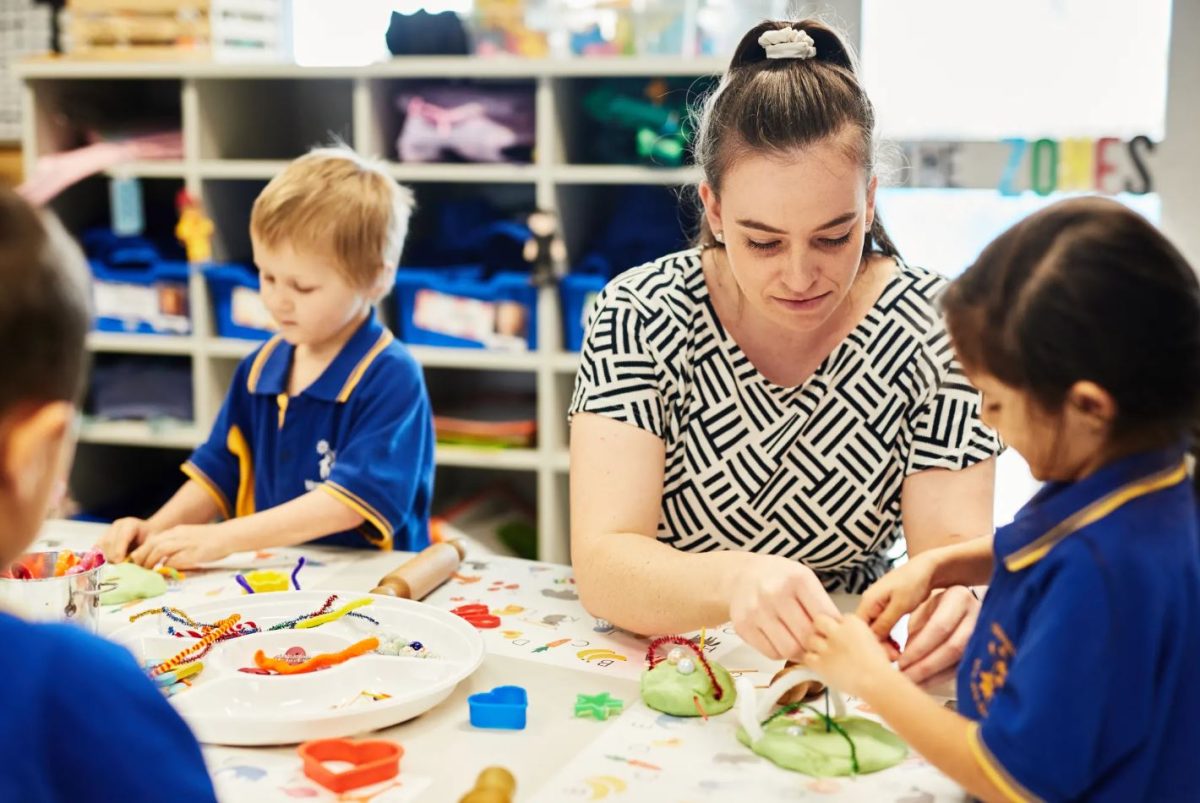 A teacher doing craftwork with a pupil