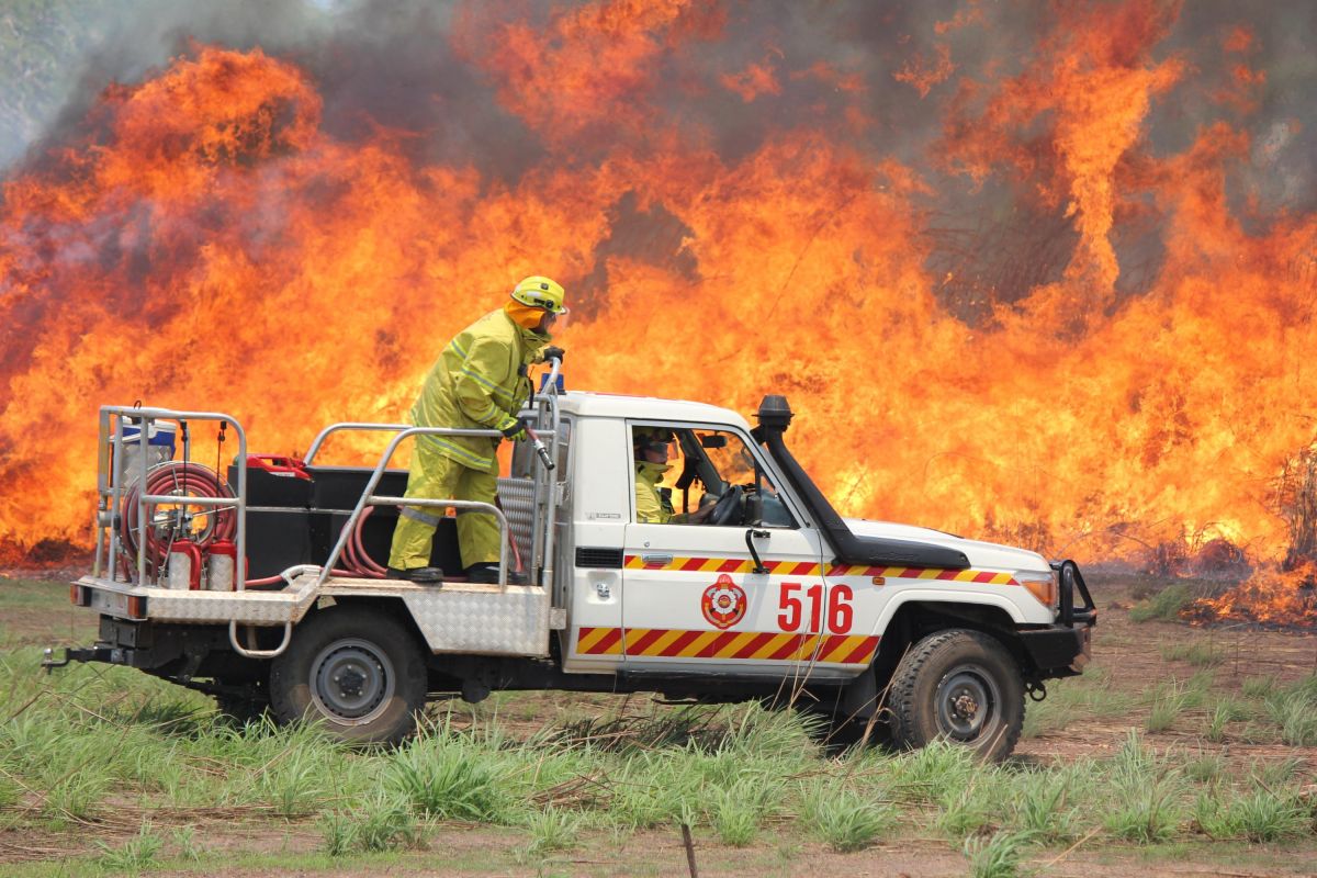 firefighters in a ute tackle a blaze in the bush
