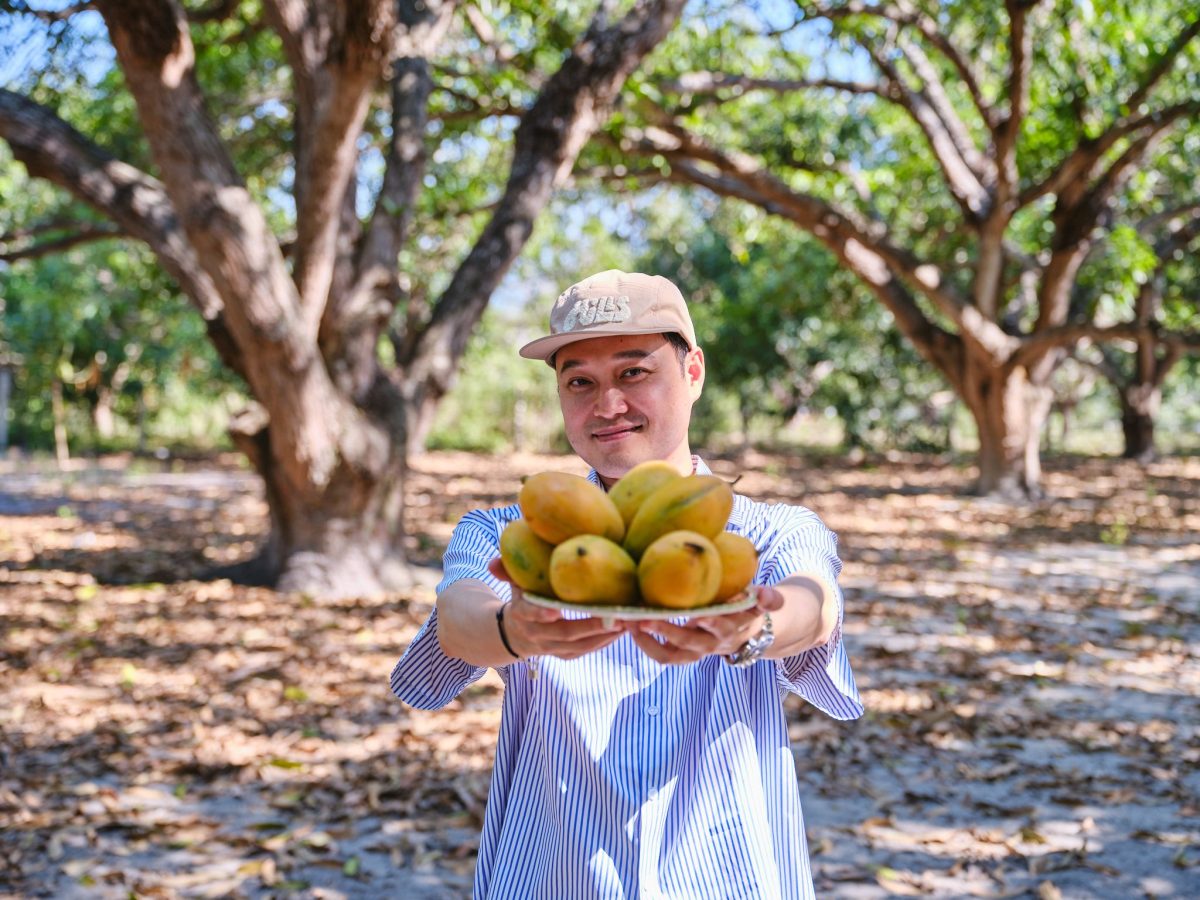 a man holding a plate of mangoes