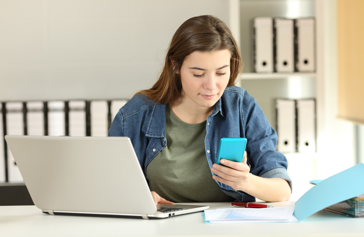 Woman with phone at computer