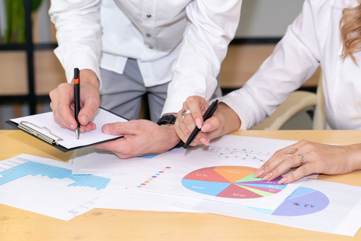 a man and a woman looking at graphs on a desk