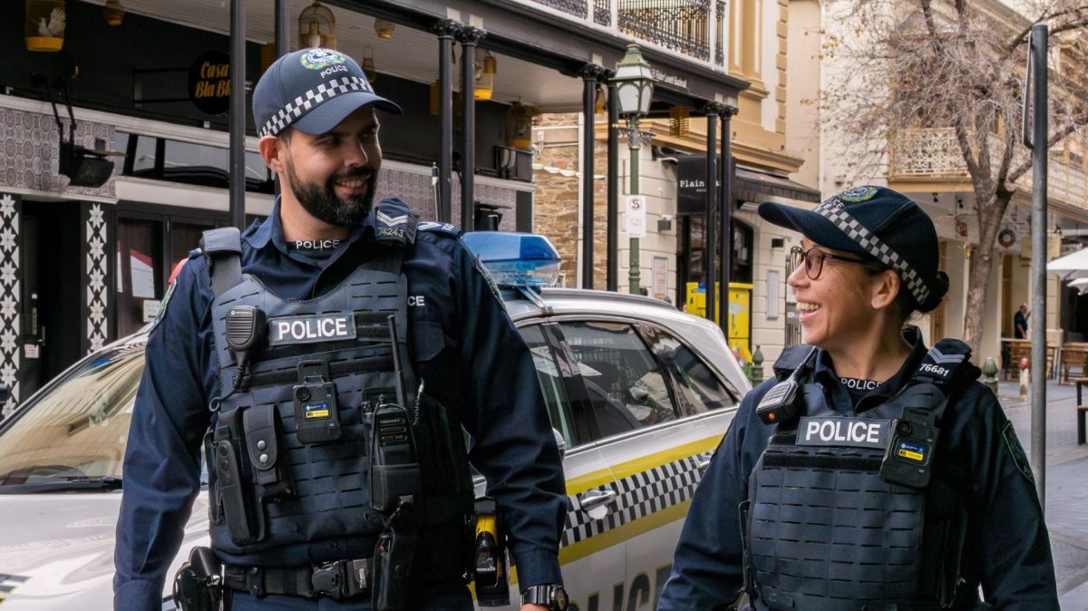 a policeman and a policewoman walking along a street