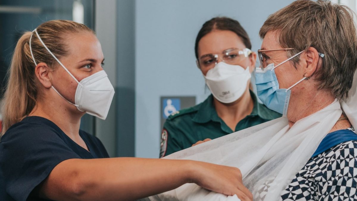 healthcare workers with a patient wearing a sling