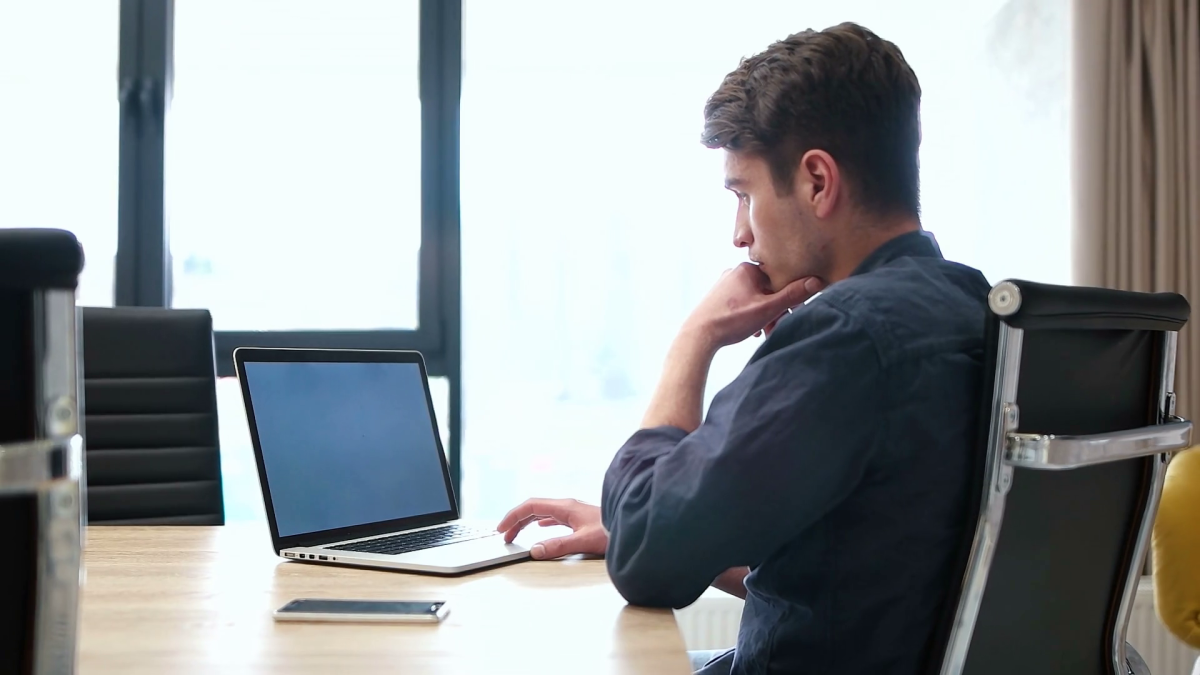 A man using his laptop on an office table