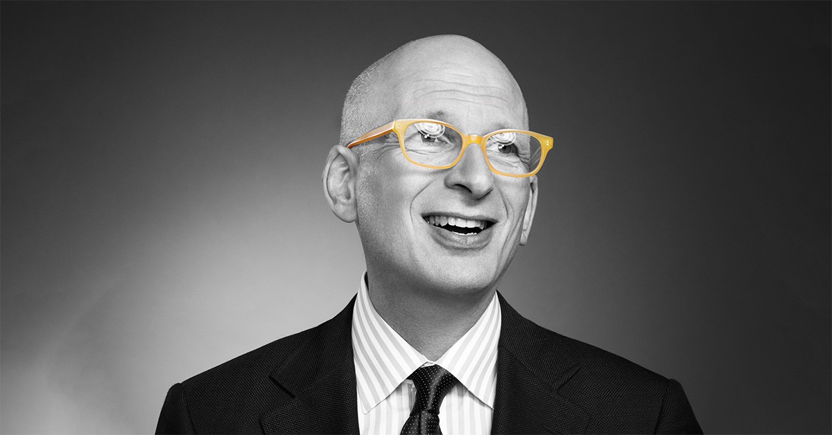 man wearing a suit and orange-rimmed glasses