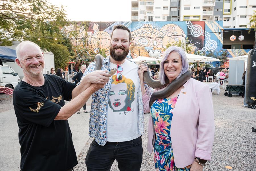 two men and a woman with a big snake