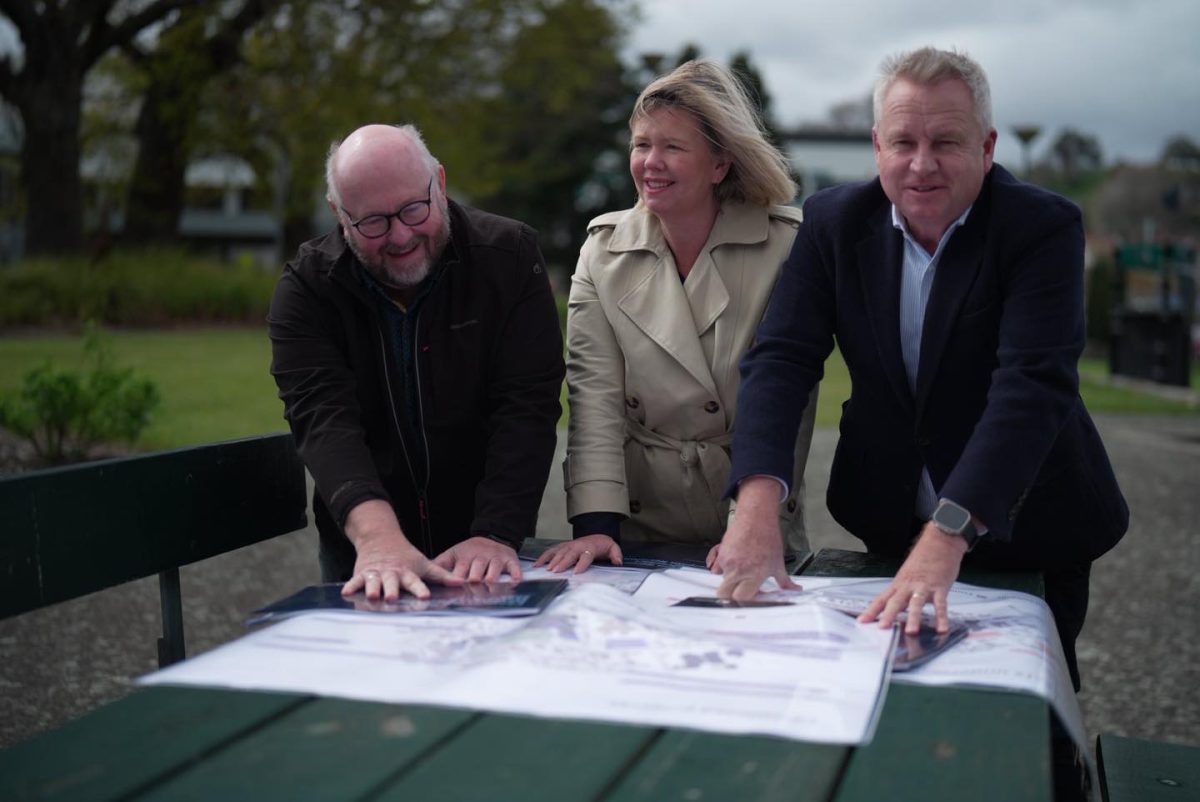 three people looking at building plans