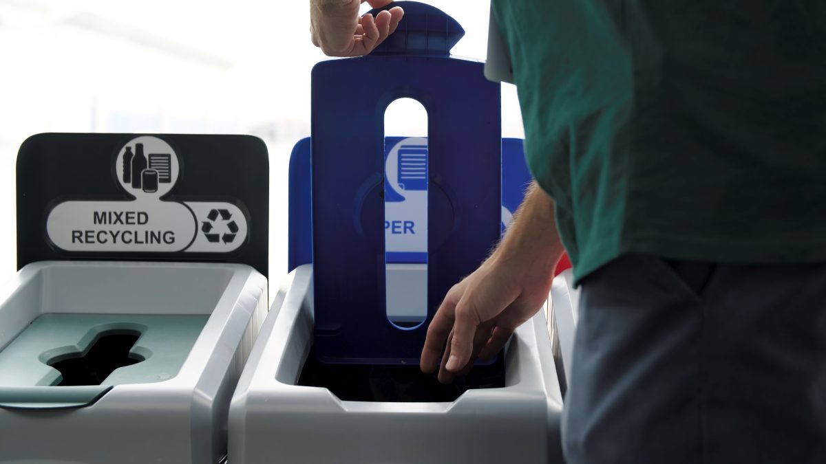 A person using a paper-recycling container