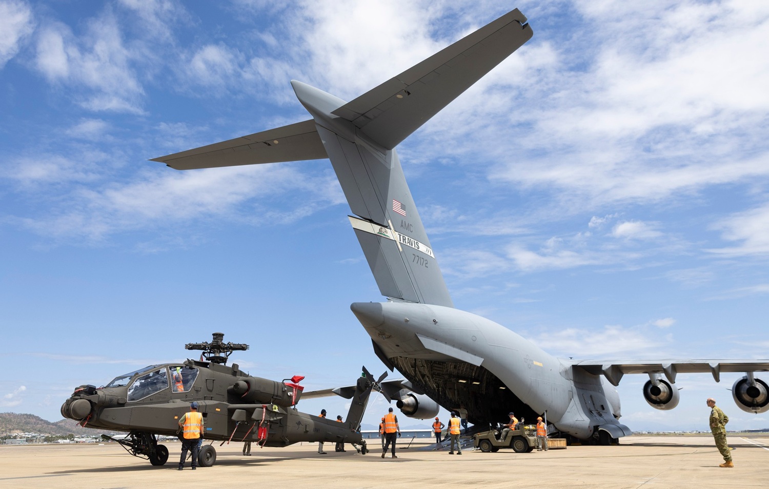 Army helicopter being unloaded from a transport plane