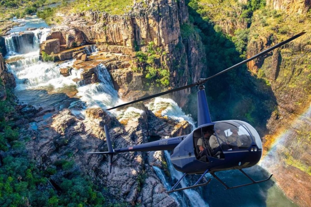 helicopter flying over waterfall in national park