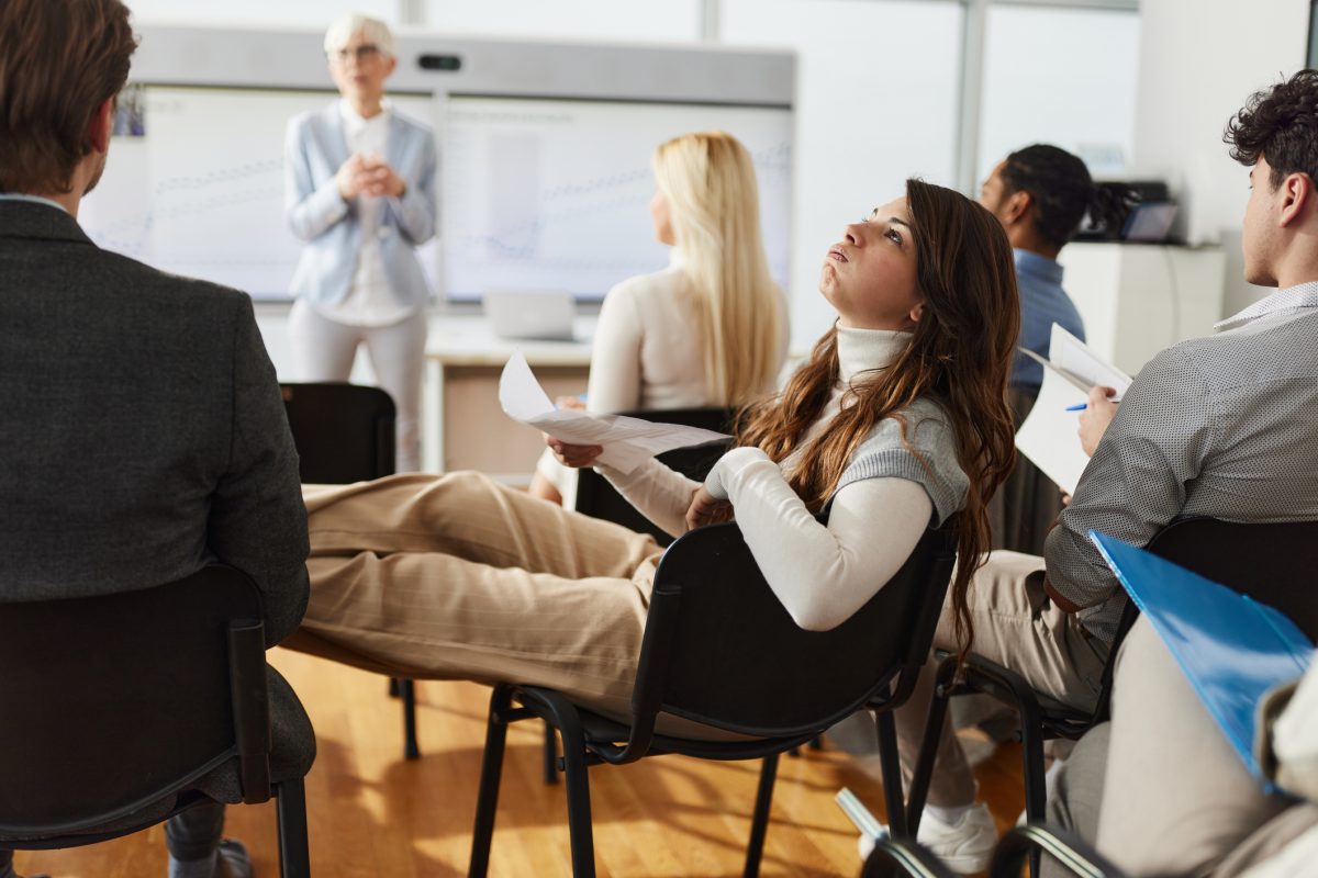 Bored woman in a seminar with her colleagues in boardroom