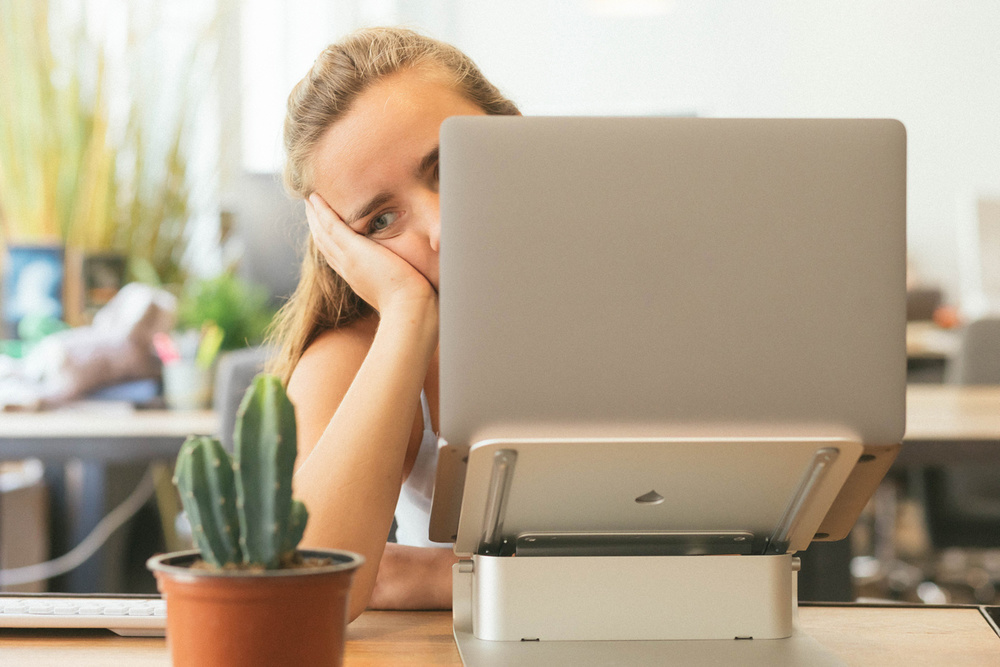 Unmotivated woman behind laptop
