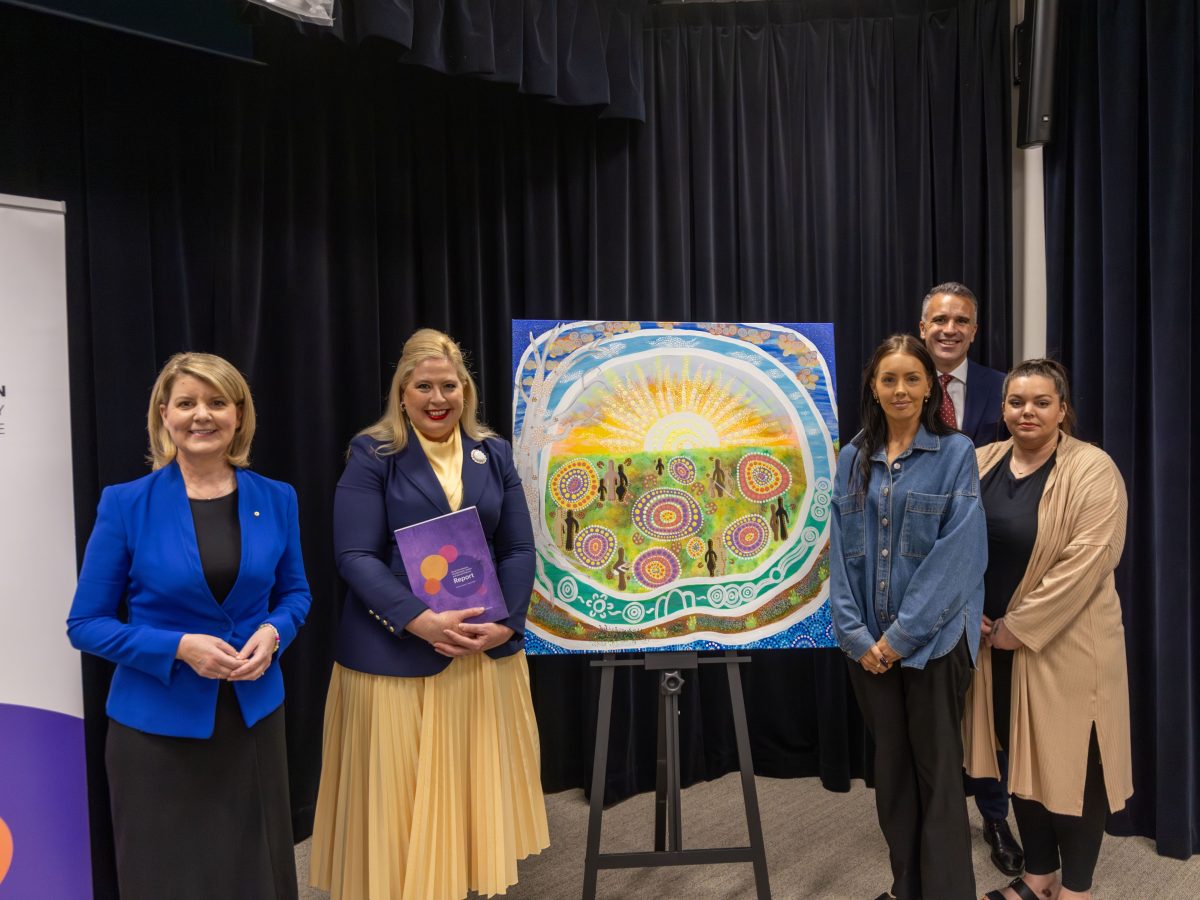 A group of people standng in front of artwork