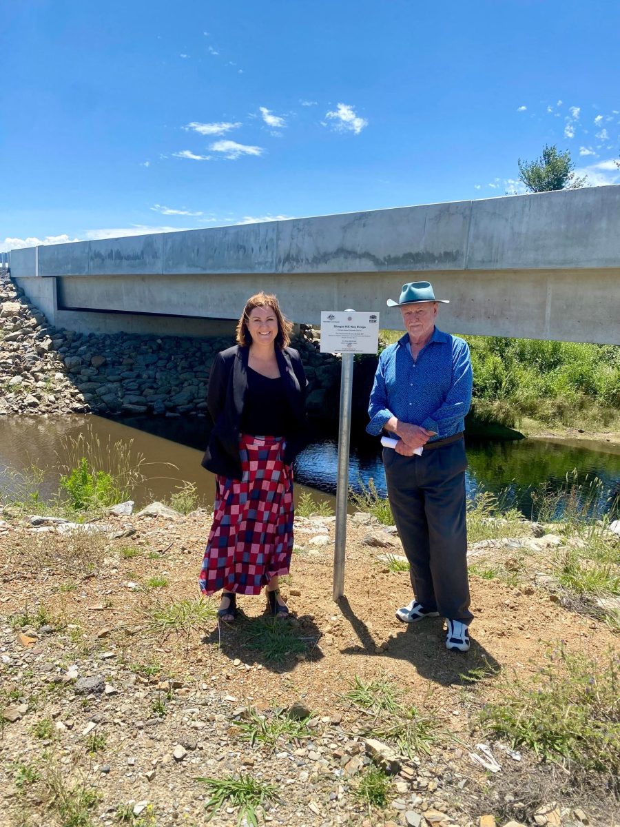 Woman and man standing near new bridge sign 