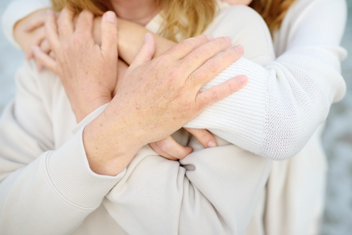 Closeup of embrace between adult daughter and her mother