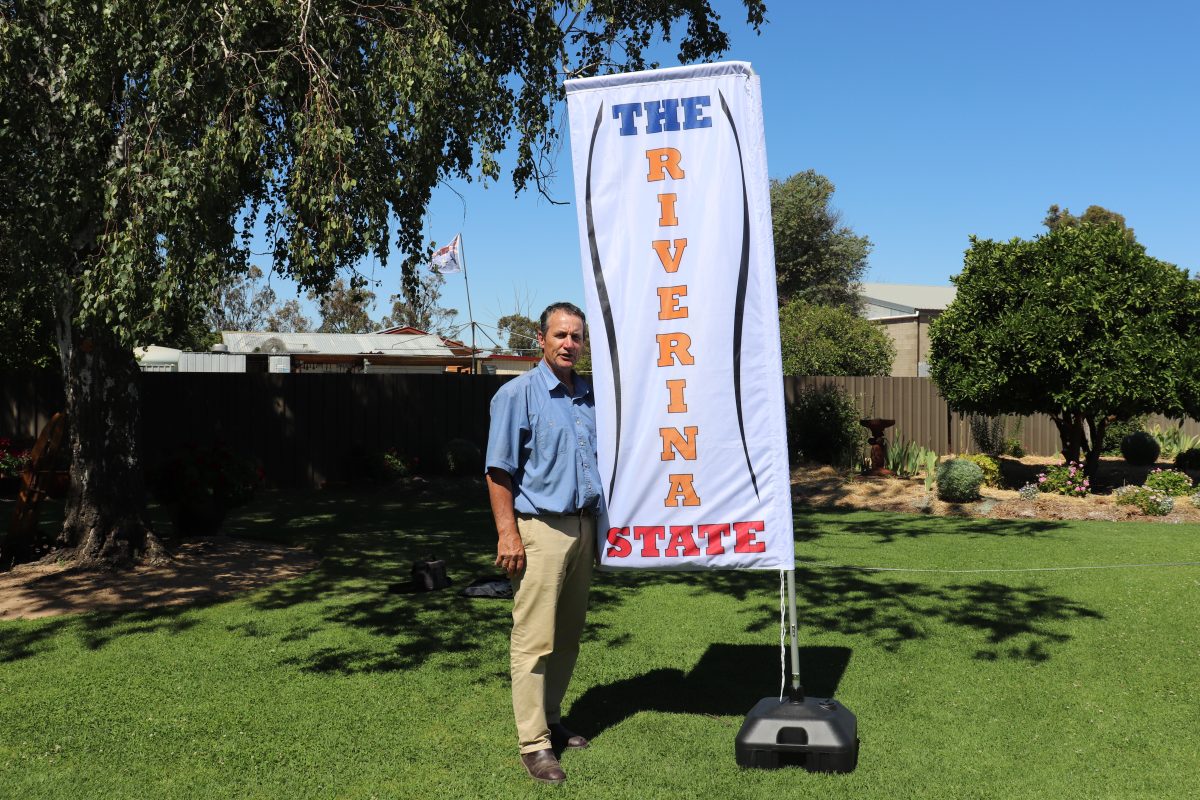 A man standing next to a banner