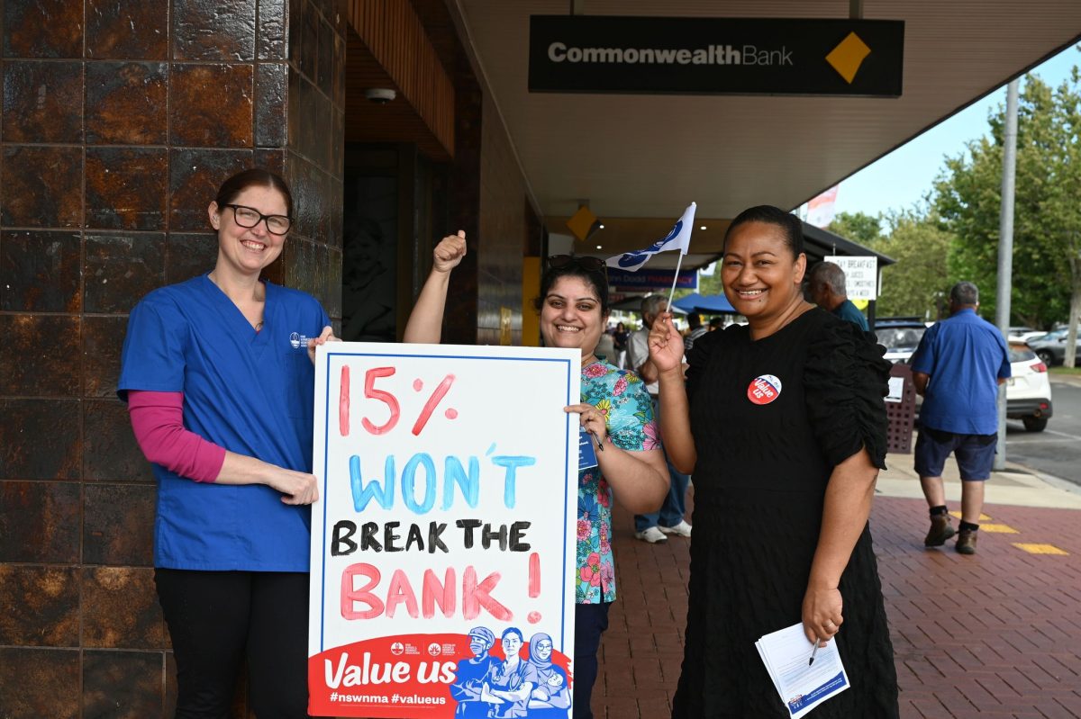 Three nurses with placard