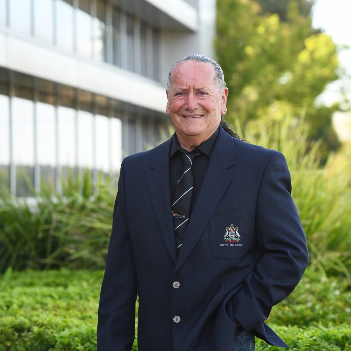Man wearing a blazer with a city council logo